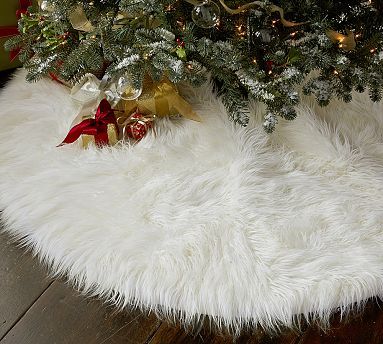 a white sheepskin rug next to a christmas tree