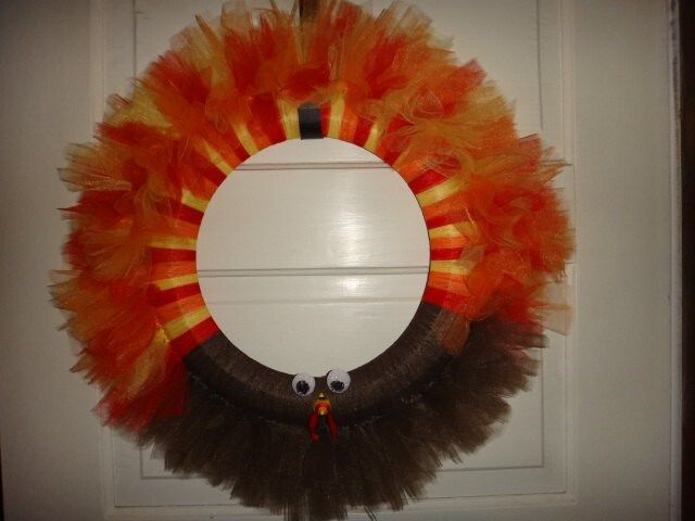 an orange and black wreath hanging on the front door