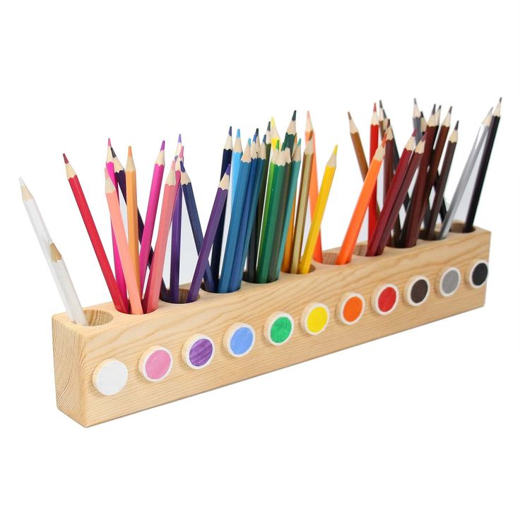 a wooden pencil holder filled with lots of colored pencils