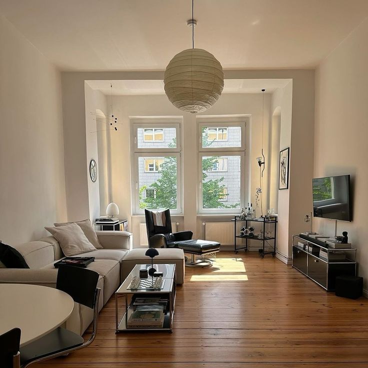 a living room filled with furniture and a flat screen tv on top of a wooden floor