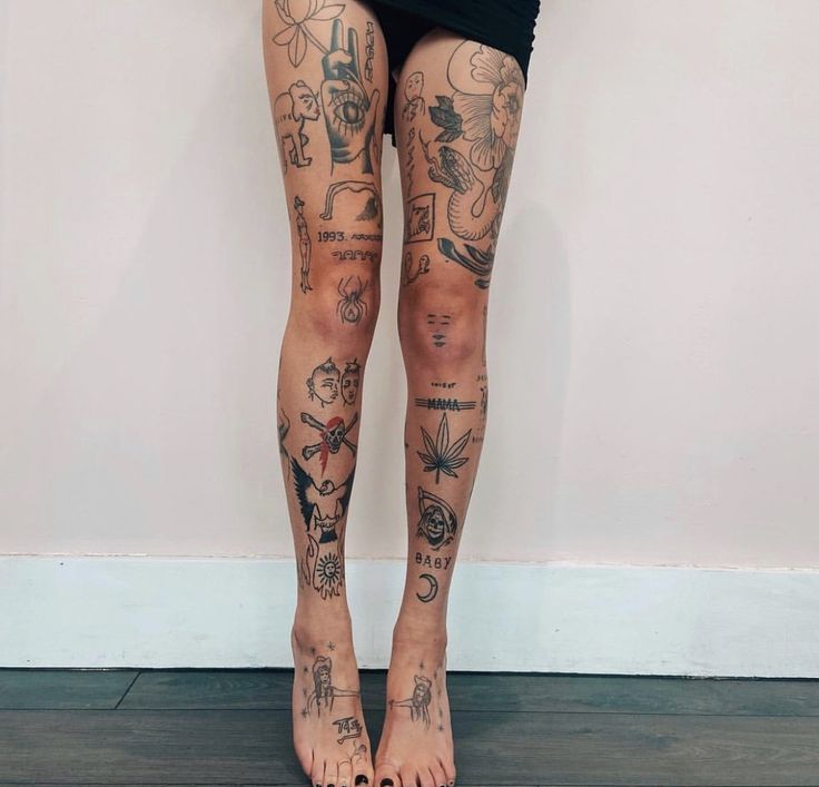 a woman's legs with tattoos on them are shown in front of a white wall