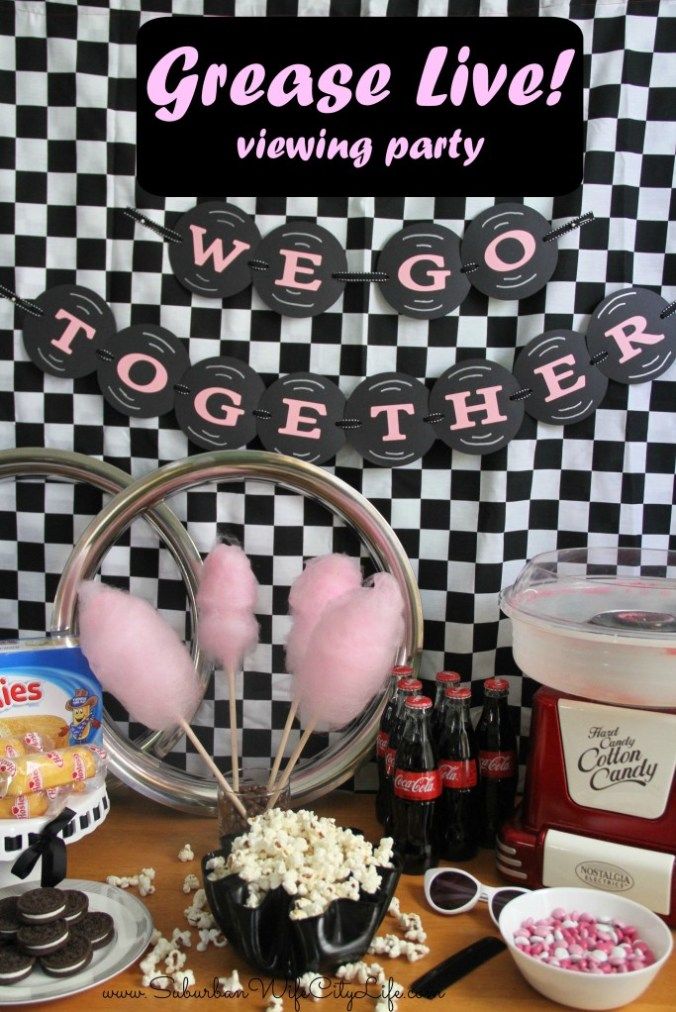 a table topped with lots of food and desserts next to a sign that says grease live viewing party