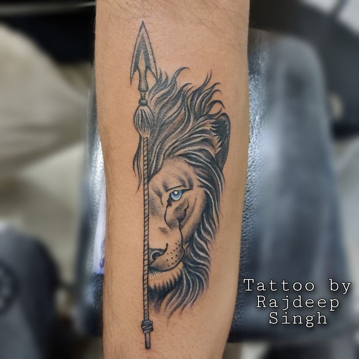 a lion with a bow and arrow tattoo on his arm is shown in this image