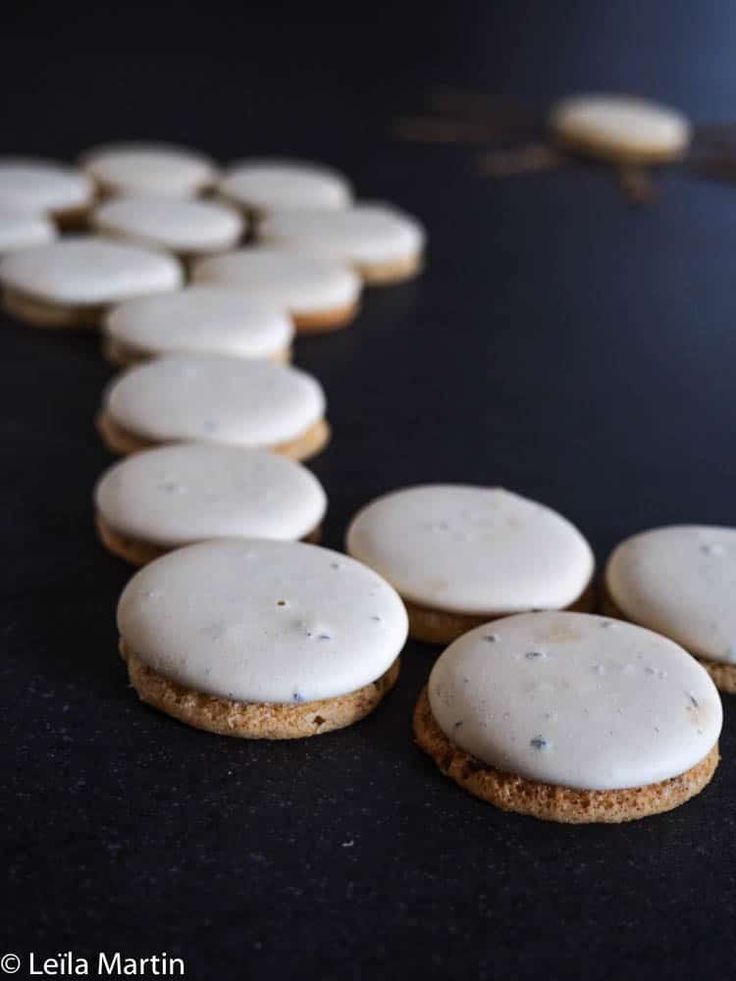 cookies with white frosting are lined up on a table