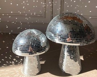 two shiny disco balls sitting next to each other on top of a tiled floor in front of a door