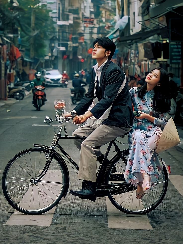 a man and woman riding on the back of a bicycle