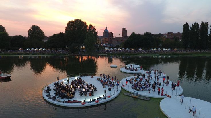 an aerial view of several floating platforms in the water with people standing on them at sunset