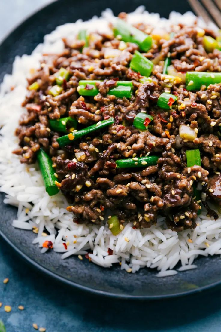 a black plate topped with rice and ground beef