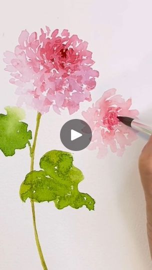 someone is drawing flowers with watercolors on paper