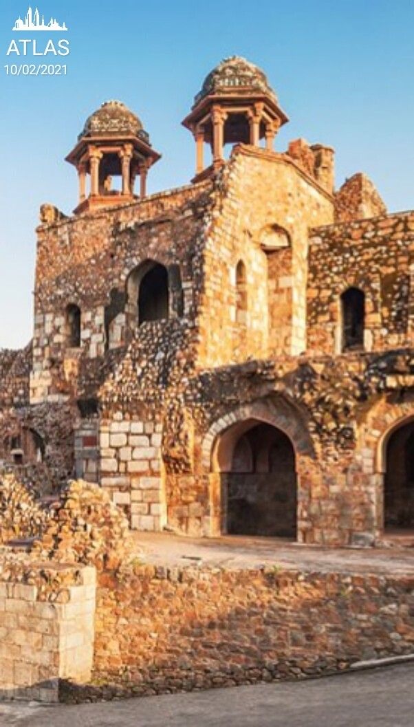 an old brick building with two towers and arched doorways in the middle of it