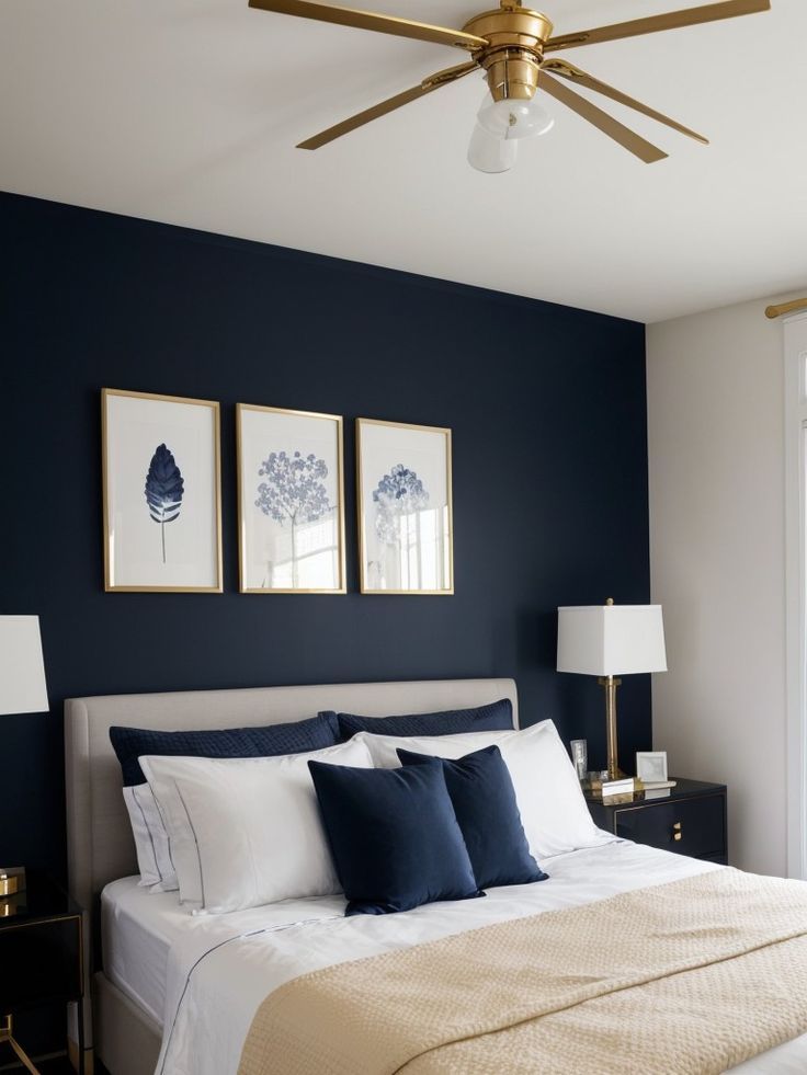 a bedroom with blue walls, white bedding and two framed pictures on the wall