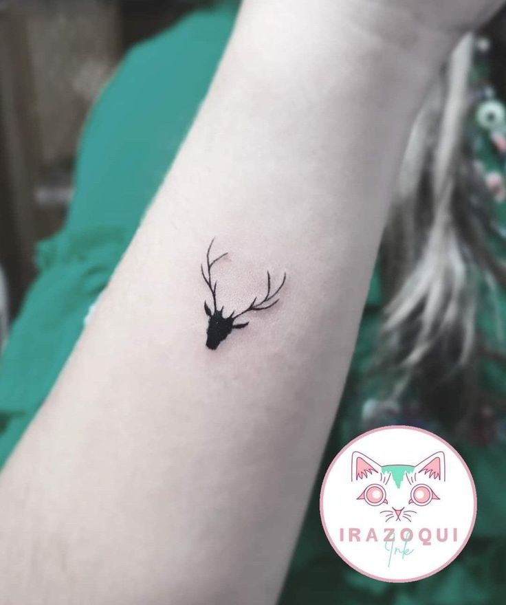 a small deer head tattoo on the arm