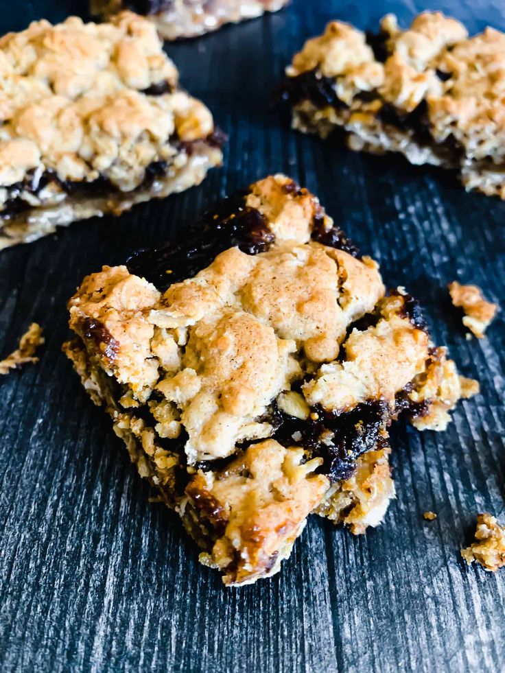 blueberry crumbled bars on a table with one cut in half and the other partially eaten