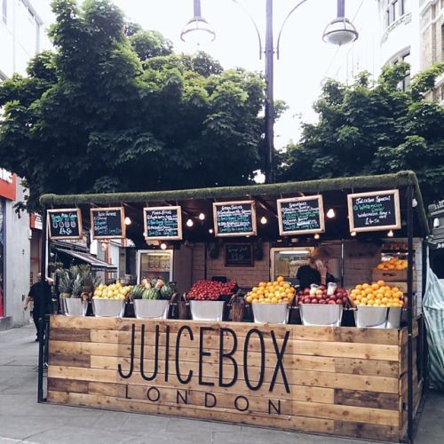 a fruit and vegetable stand on the sidewalk