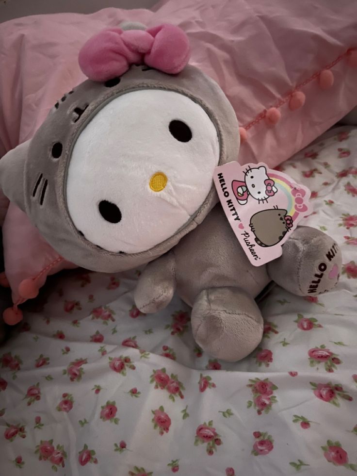 a hello kitty stuffed animal laying on top of a bed