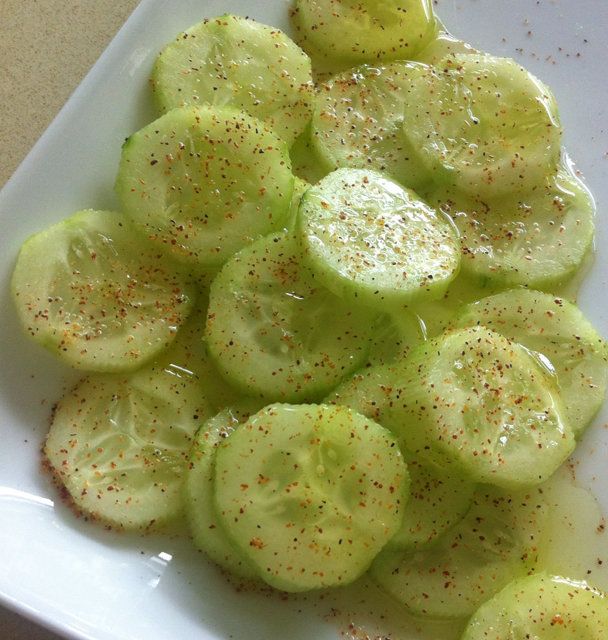 sliced cucumbers on a white plate with pepper sprinkles