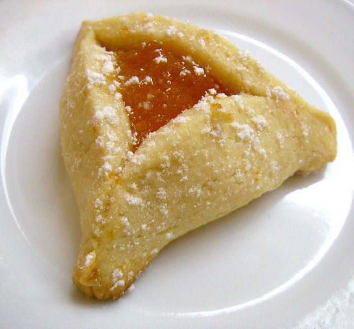 a piece of food on a plate with powdered sugar and jelly in the middle