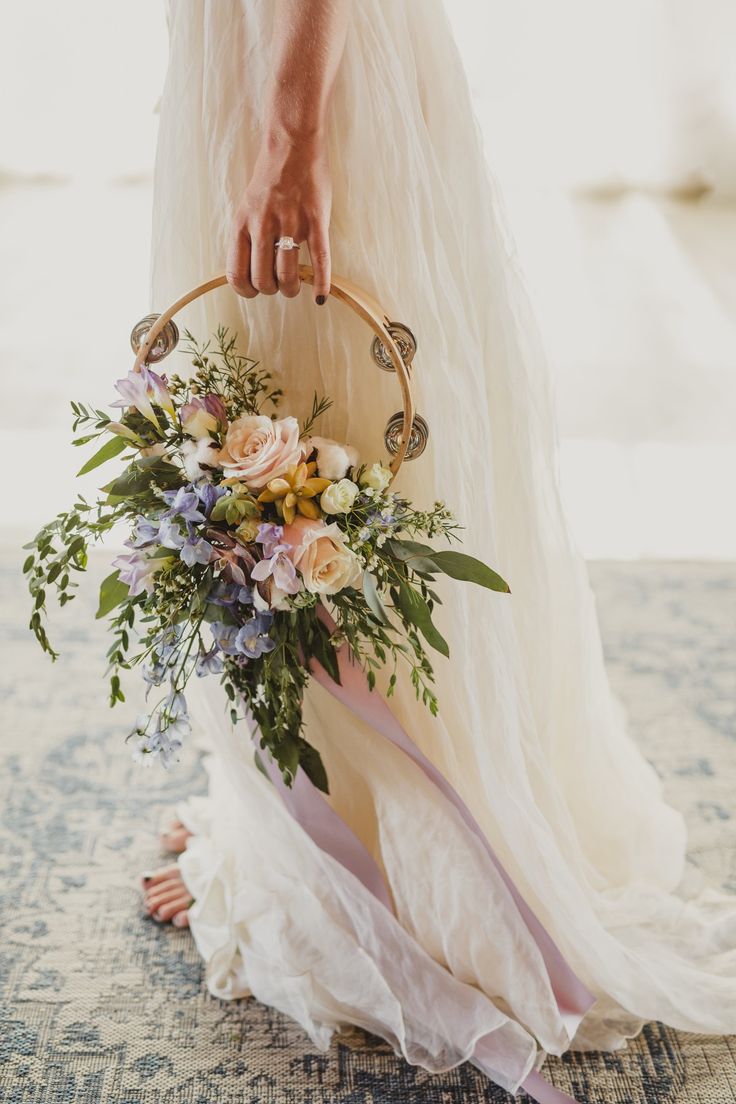 a woman holding a basket with flowers in it on top of a carpeted floor