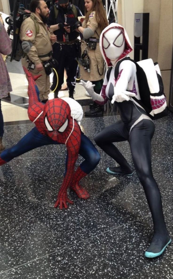 two people dressed as spider - man and the amazing spider - man are posing for pictures