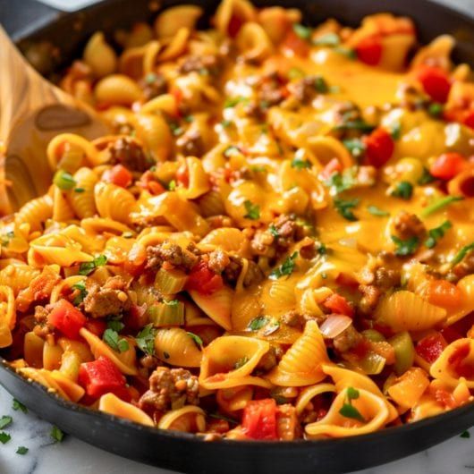 a skillet filled with pasta and sausage