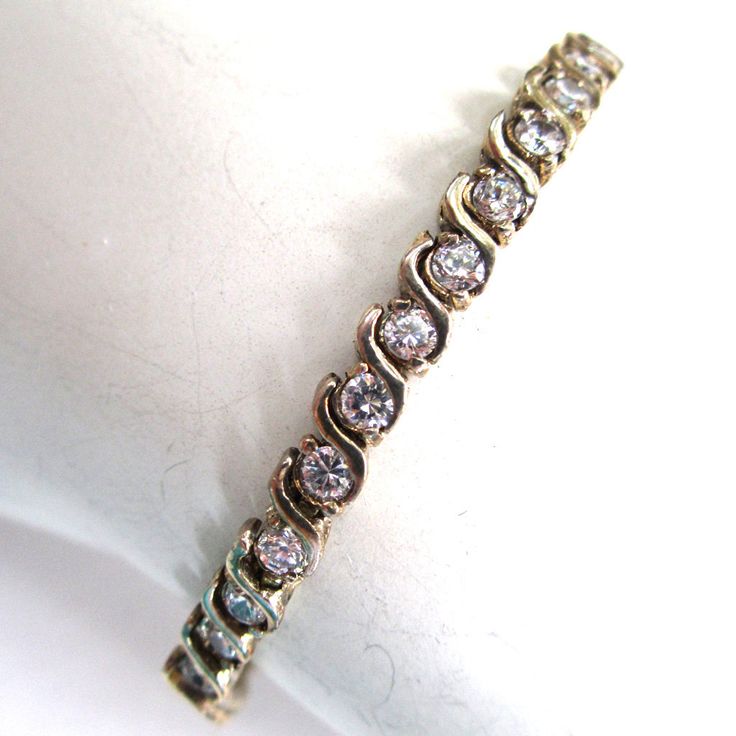 "Sparkly, shimmery fun for a fraction of the price of real diamonds! This tennis bracelet is made of sterling silver and is set with bright glass stones in a line Very well-made. Marked 925 in a couple places near the clasp. Excellent condition. Two safety clasps keep the bracelet securely on your wrist. Measures 7 1/2\" in length and 1/8\" wide." Seed Bead Purse, Buyable Pins, Silver Necklace Set, Rhinestone Tiara, Solitaire Pendant Necklace, Beaded Purses, Solitaire Pendant, Silver Rhinestone, Stylish Jewelry