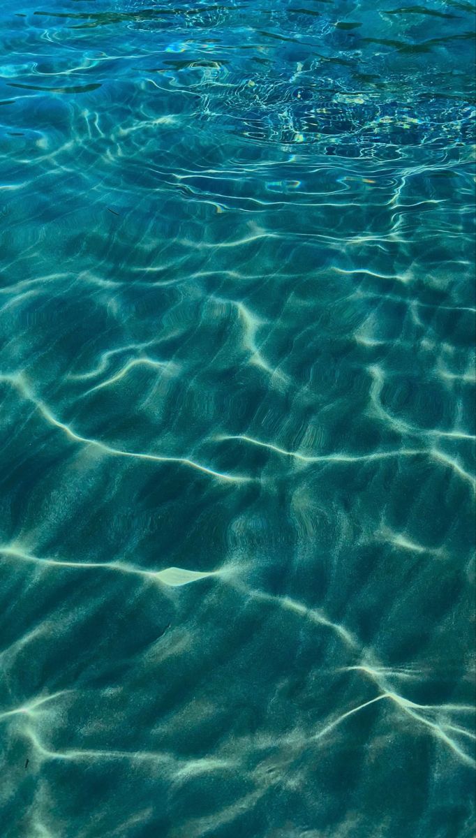 the water is very clear and blue with ripples on it's surface,