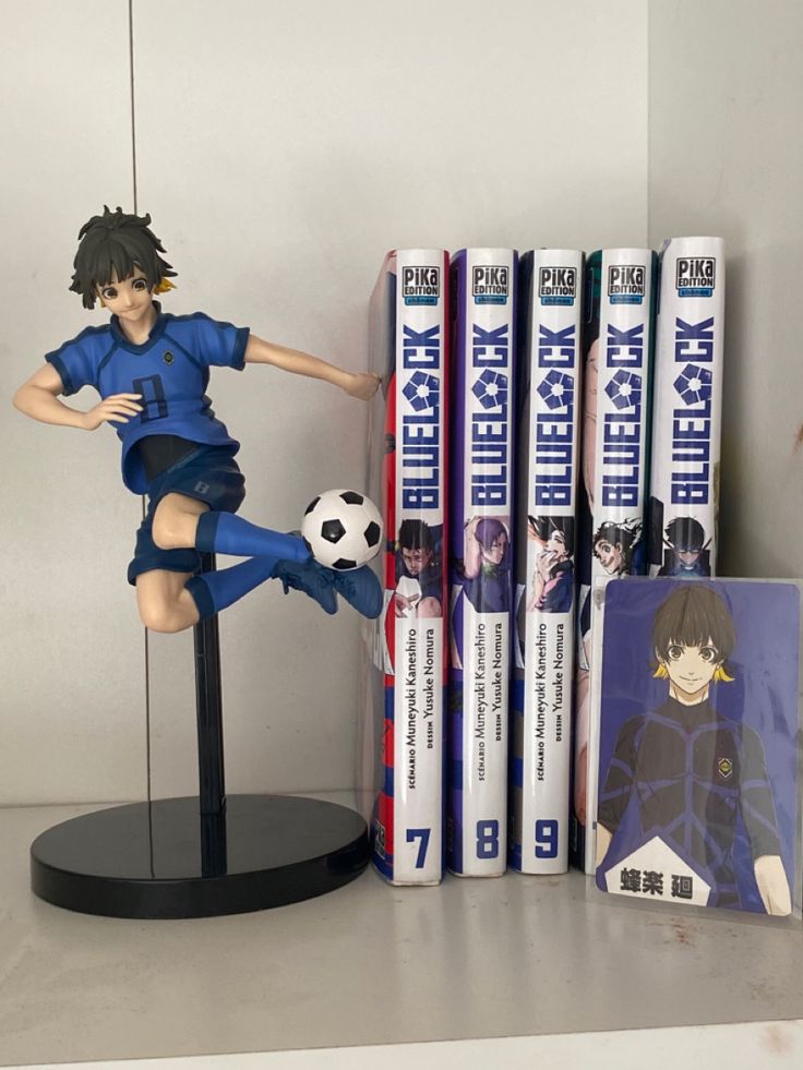 a figurine sitting on top of a table next to some books and dvd's