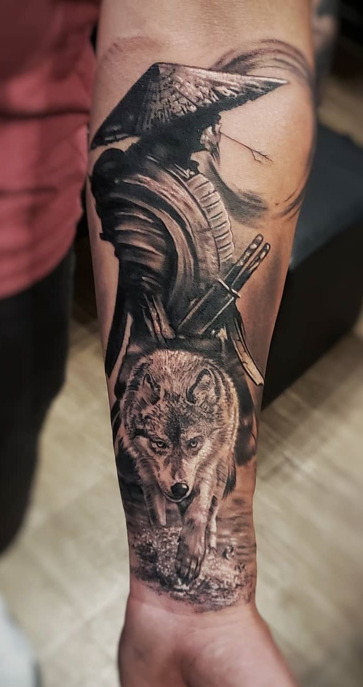 a man's arm with a wolf and an eagle on it, in black and grey