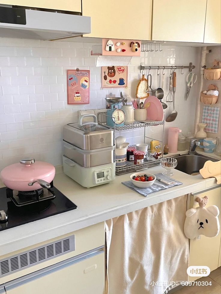 a kitchen with white cabinets and counter tops filled with dishes, cups and utensils