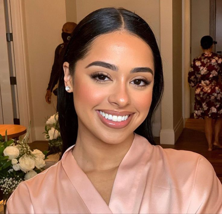 a woman in a pink robe smiling at the camera