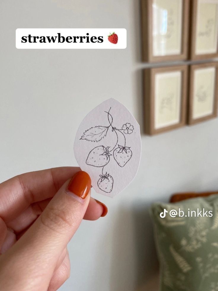 someone holding up a sticker with some fruit on it