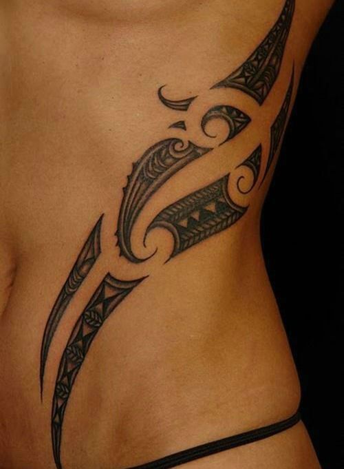 a woman's stomach with a tattoo design on the side and an arrow in the middle