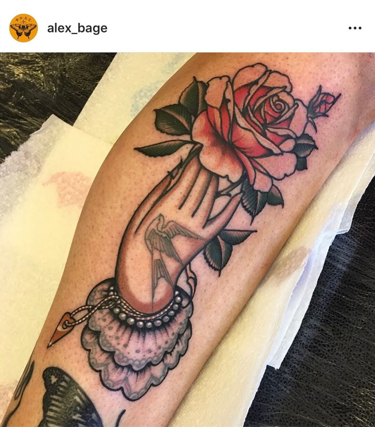 a woman's arm with a rose on it and a butterfly in the middle