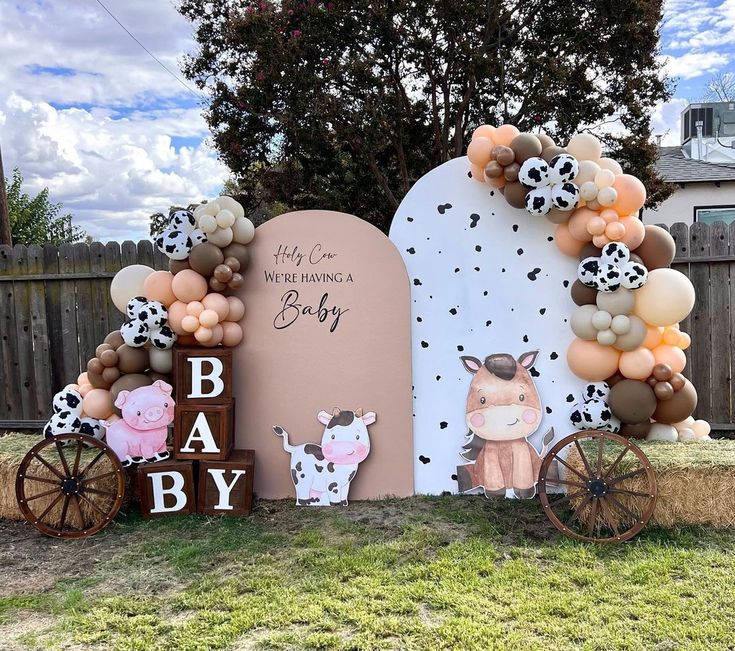 a baby shower sign with balloons and farm animals on it, along with other decorations