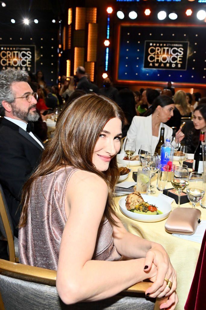 a woman sitting at a table in front of people