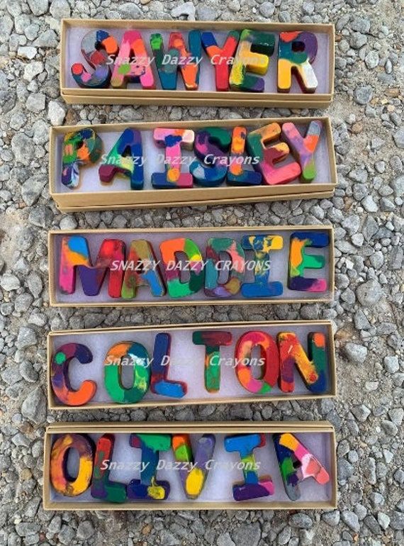 three boxes filled with different colored letters on top of a gravel covered ground next to each other