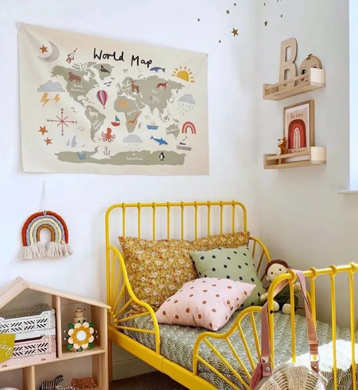 a child's bedroom with a yellow metal bed