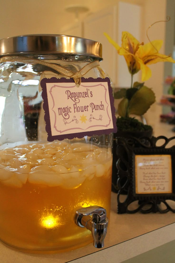 a jar filled with liquid sitting on top of a counter next to a flower pot