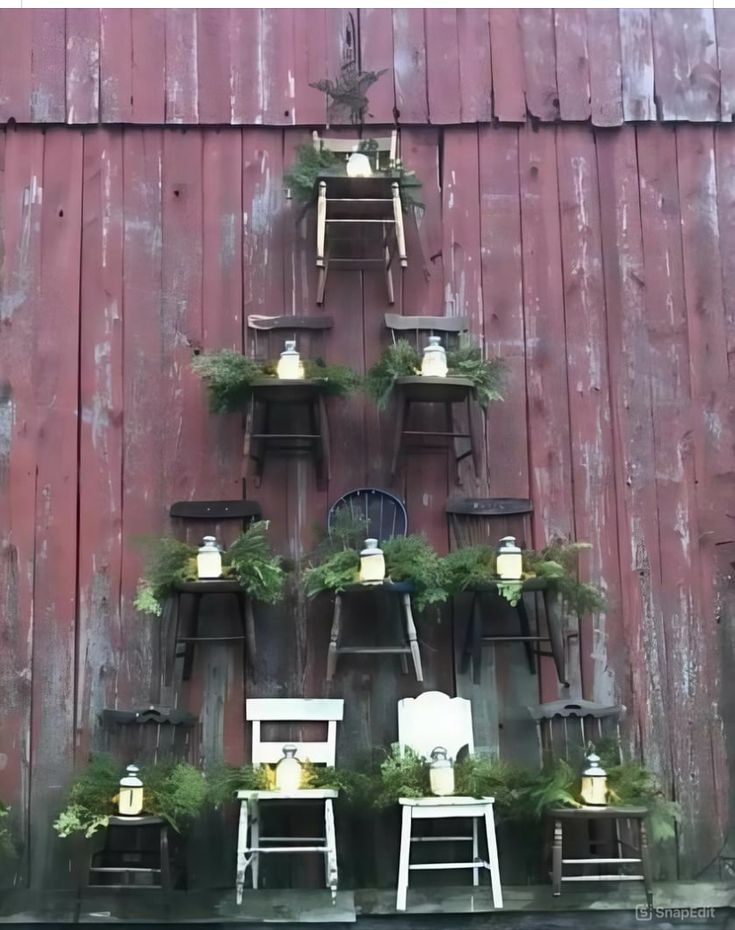 an old red barn with chairs and plants on it