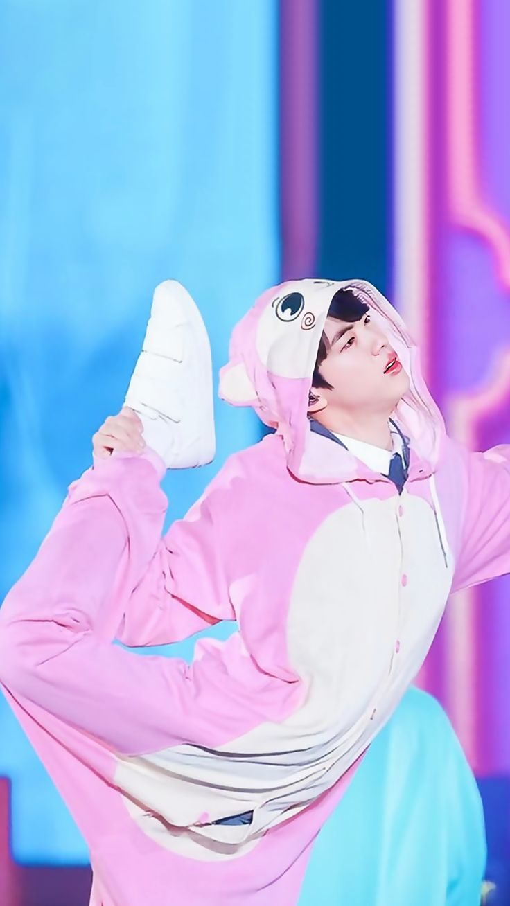 a man in a pink bunny suit holding a pair of white shoes while standing on stage