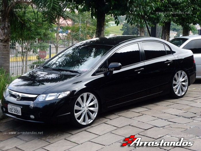 a black car parked in front of some trees