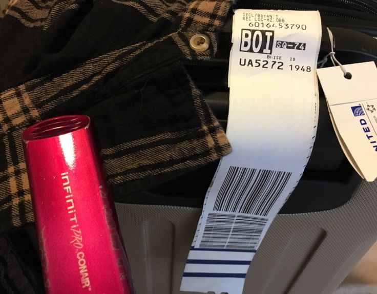 the label is on top of a suitcase with luggage tags attached to it's handles