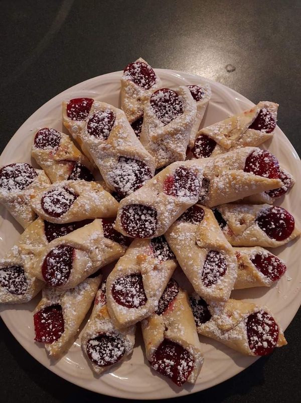 a white plate topped with pastries covered in powdered sugar on top of a table