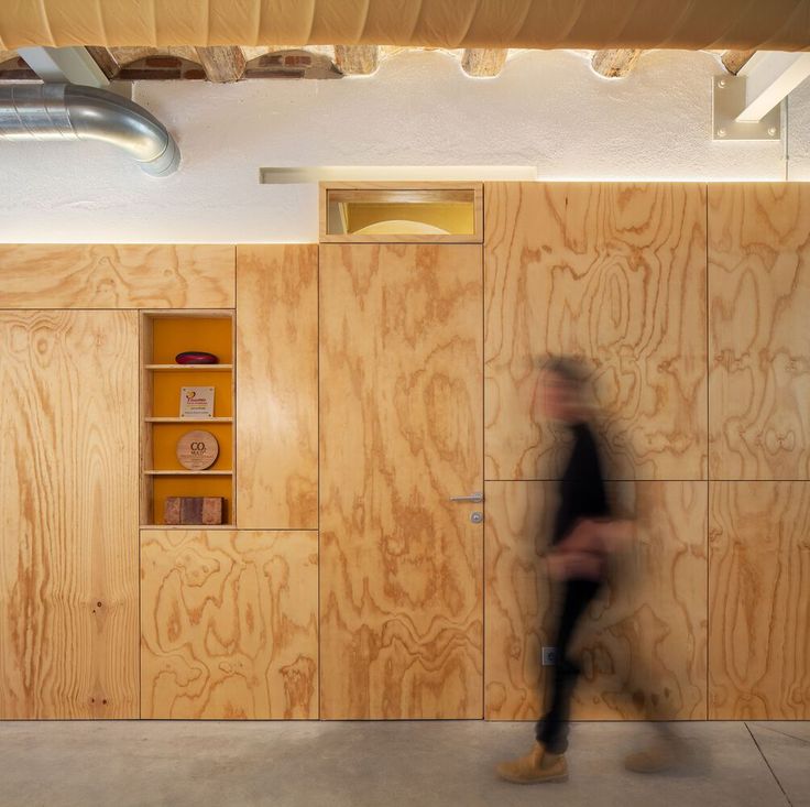 a blurry photo of a person walking in front of some wood paneled walls