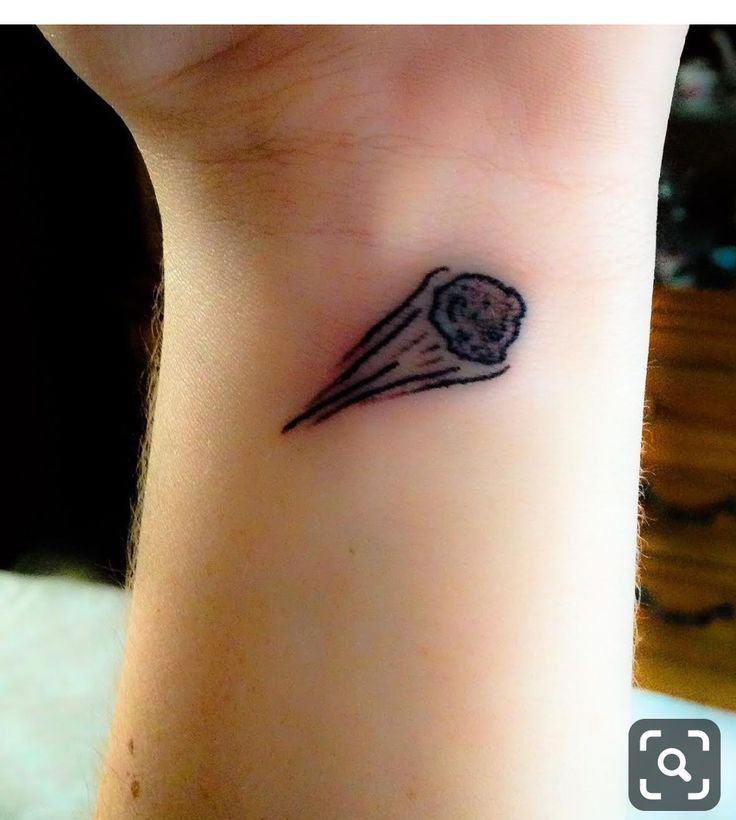 a small tattoo on the wrist of a woman's left arm that has a flower in it