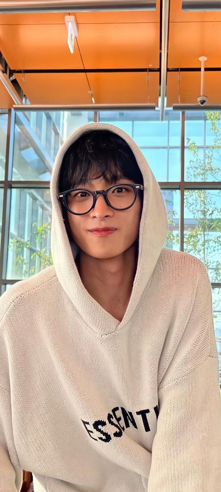 a person wearing glasses and a hoodie