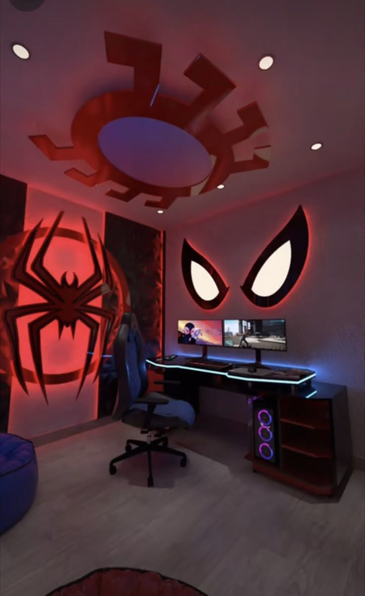 a computer desk topped with a monitor next to a spiderman mural