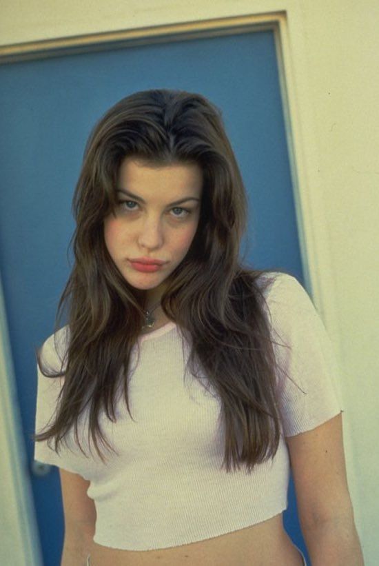 a woman in white shirt and shorts posing for the camera with her hands on her hips