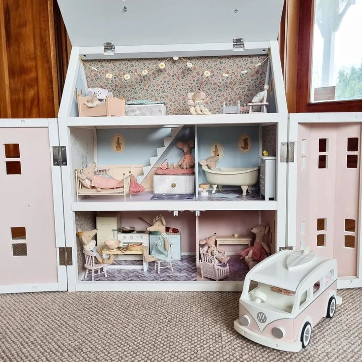 a doll house with furniture and accessories in the floor next to a toy car on the ground