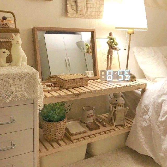 a bed room with a neatly made bed and a clock on the shelf next to it